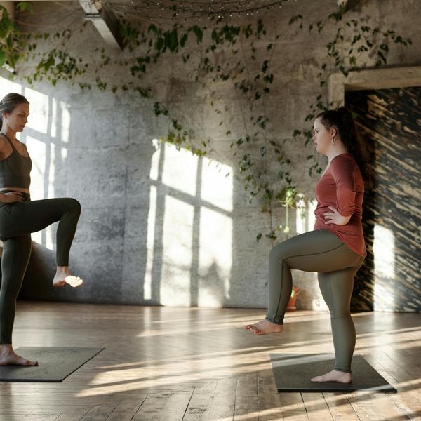 Person peacefully stretching in a sunlit room, embodying well-being.